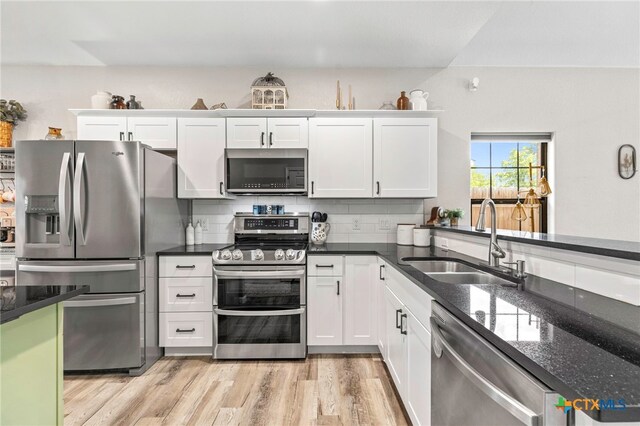 312 Holly Ave, Luling, TX 78648 - kitchen featuring stainless steel appliances, light wood-style floors, white cabinetry, and decorative backsplash