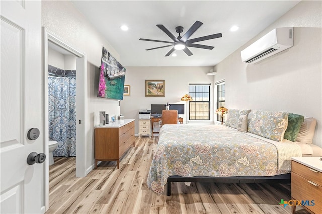 312 Holly Ave, Luling, TX 78648 - bedroom with a wall mounted AC, light wood finished floors, recessed lighting, ceiling fan, and connected bathroom