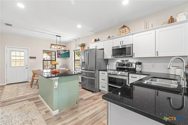 312 Holly Ave, Luling, TX 78648 - kitchen with appliances with stainless steel finishes, a center island, light wood-type flooring, white cabinets, and recessed lighting