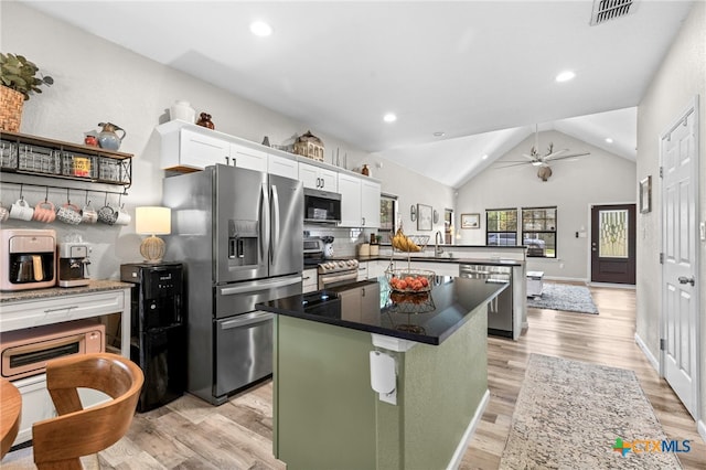 312 Holly Ave, Luling, TX 78648 - kitchen with appliances with stainless steel finishes, a peninsula, light wood-style floors, a center island, and white cabinets