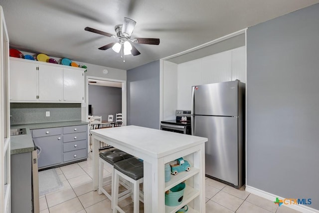 2812 Curlew St, Victoria, TX 77901 - kitchen featuring stainless steel appliances, light tile patterned floors, ceiling fan, light countertops, and open shelves