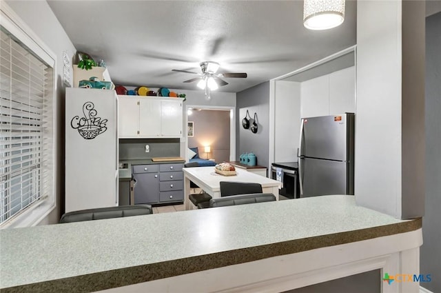 2812 Curlew St, Victoria, TX 77901 - kitchen featuring freestanding refrigerator, a ceiling fan, and white cabinets