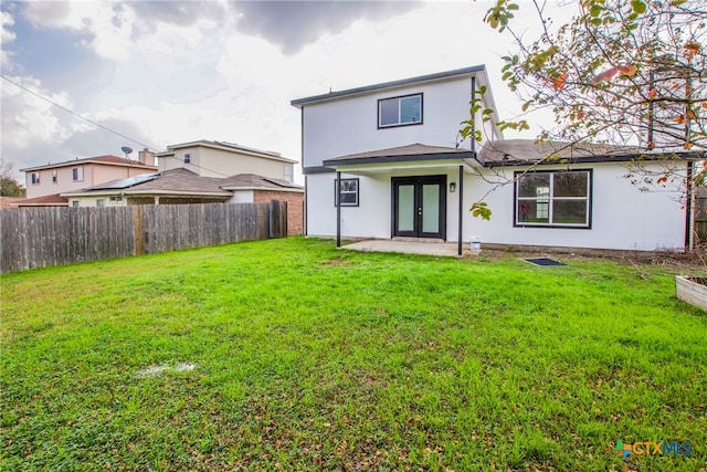 rear view of house with a yard, a patio area, and french doors