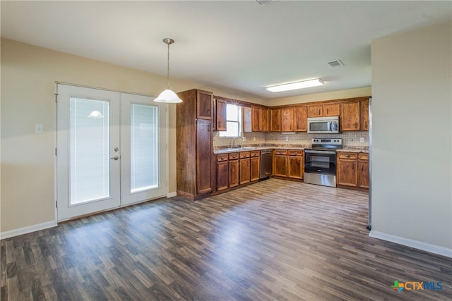 kitchen featuring pendant lighting, french doors, stainless steel appliances, and dark wood-type flooring