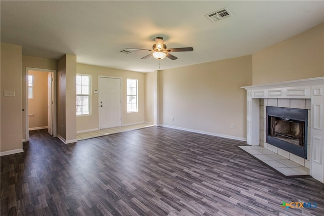 unfurnished living room featuring ceiling fan, a fireplace, and dark wood-type flooring