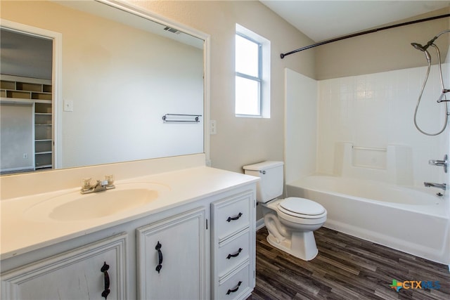 full bathroom with hardwood / wood-style floors, vanity, bathing tub / shower combination, and toilet