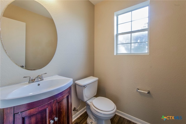 bathroom with vanity, toilet, and wood-type flooring