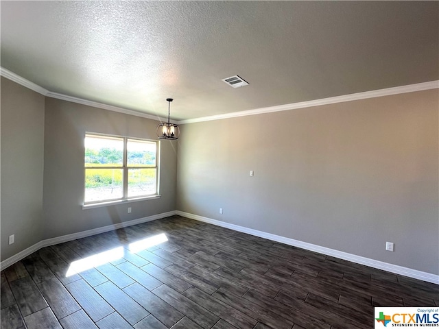 empty room featuring dark hardwood / wood-style floors, a textured ceiling, crown molding, and a notable chandelier