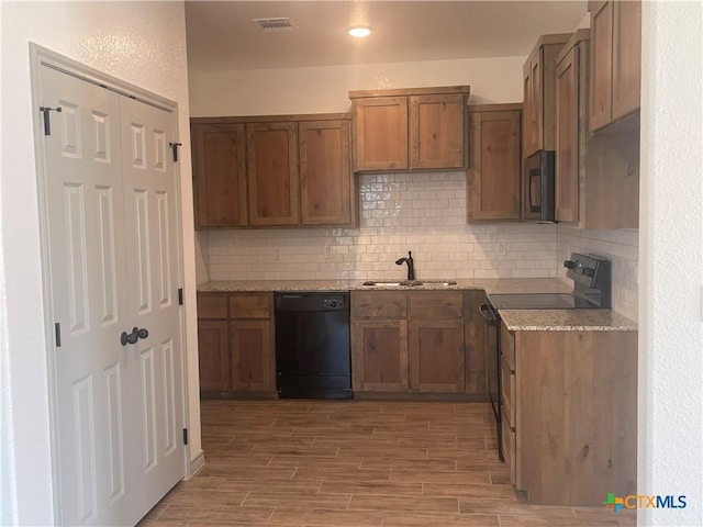2408 Duntov Dr, Temple, TX 76504 - kitchen with black appliances, a sink, light wood-style flooring, backsplash, and light stone countertops