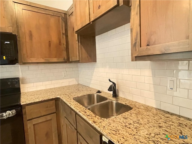 2408 Duntov Dr, Temple, TX 76504 - kitchen with a sink, tasteful backsplash, black appliances, and light stone counters