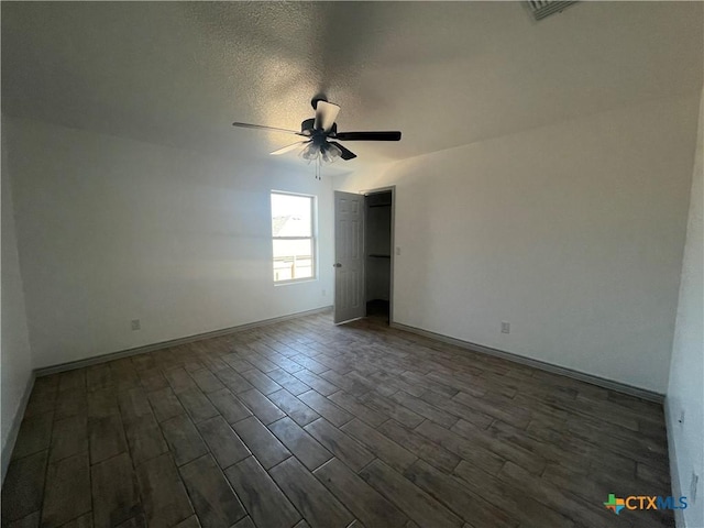 2408 Duntov Dr, Temple, TX 76504 - spare room with ceiling fan, dark wood-style flooring, baseboards, and a textured ceiling