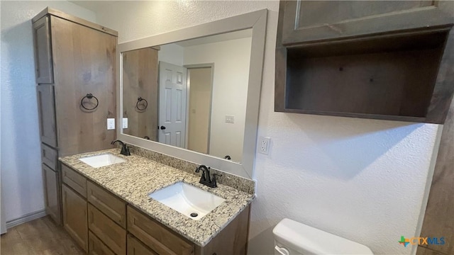2408 Duntov Dr, Temple, TX 76504 - bathroom with double vanity, toilet, a textured wall, and wood finished floors