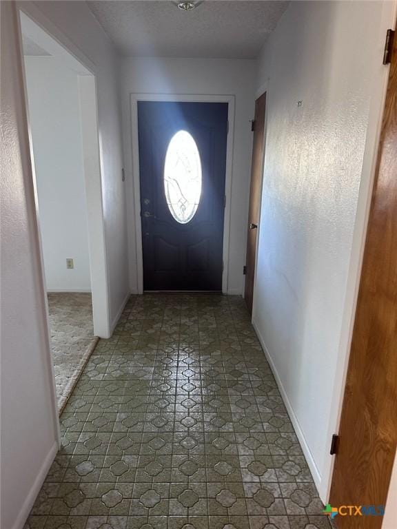 entrance foyer featuring baseboards and a textured ceiling