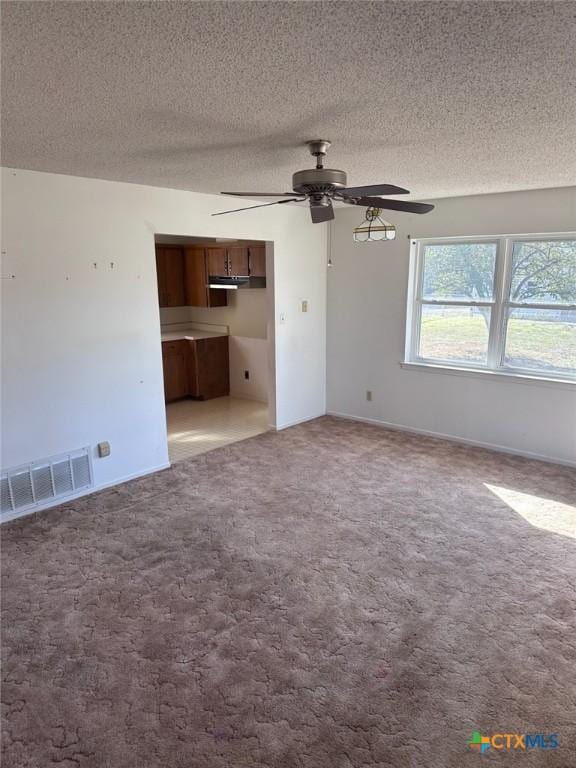 interior space featuring carpet flooring, visible vents, and a textured ceiling