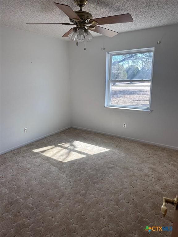 carpeted spare room featuring a ceiling fan, baseboards, and a textured ceiling