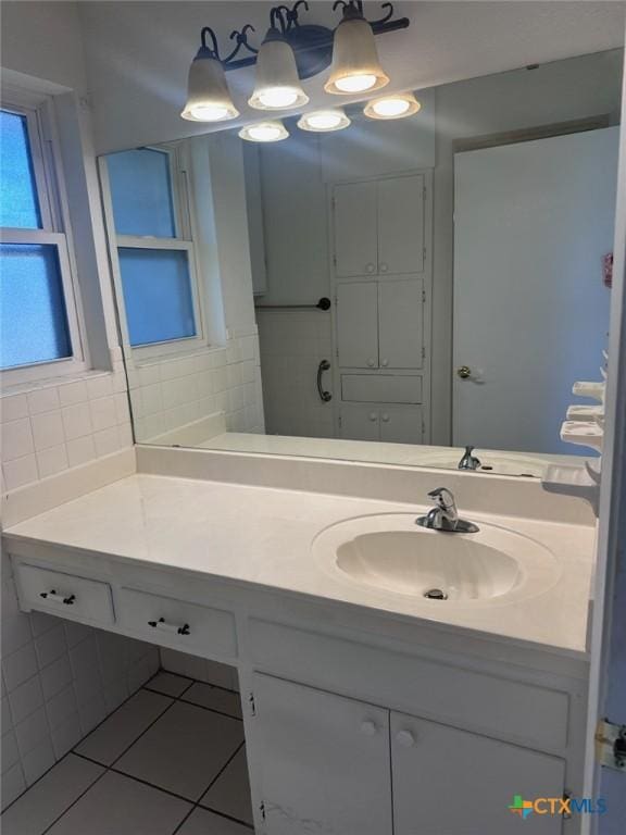 bathroom featuring tile patterned flooring, decorative backsplash, and vanity