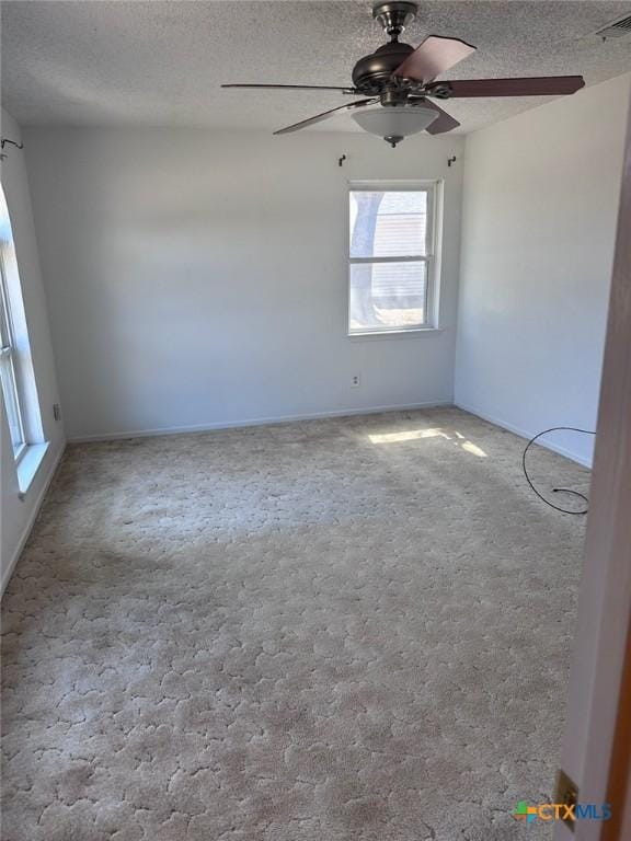 empty room with visible vents, a textured ceiling, and a ceiling fan