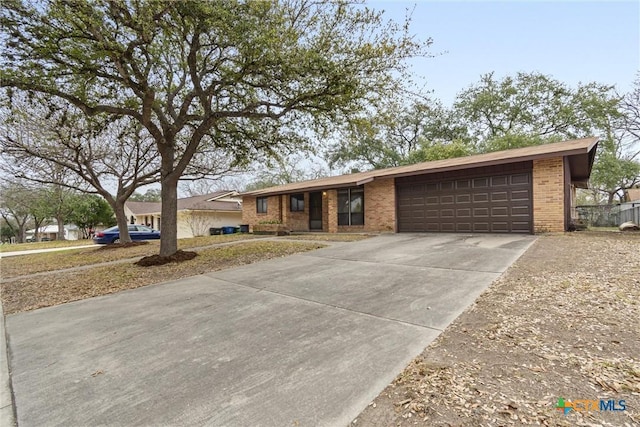 view of front of house with concrete driveway, brick siding, and an attached garage