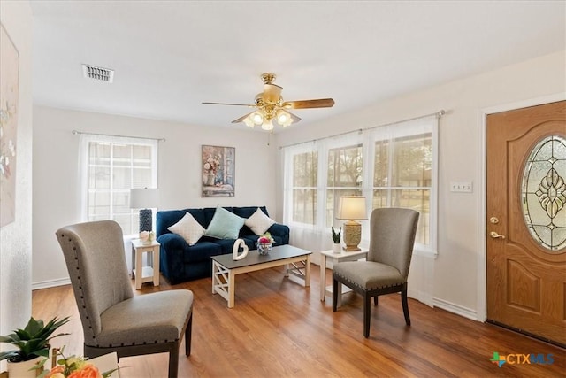 sitting room featuring baseboards, visible vents, and wood finished floors