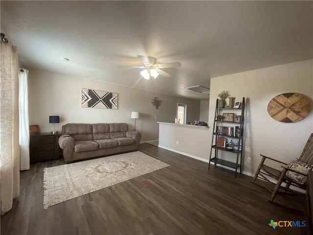 living room with dark wood-style floors, ceiling fan, and baseboards