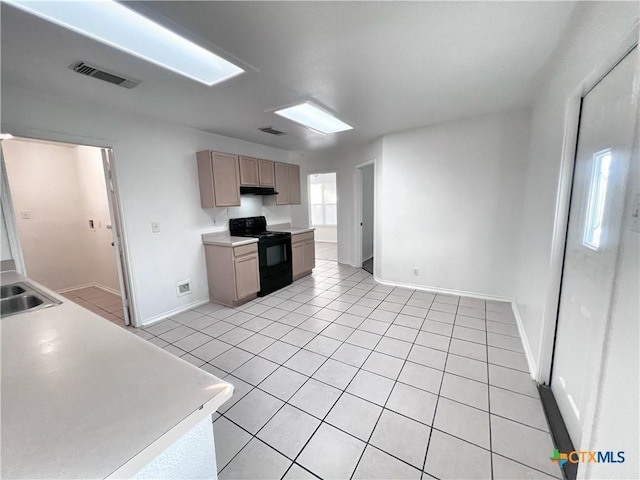 kitchen featuring light countertops, light tile patterned flooring, black range with electric stovetop, and visible vents