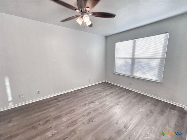 unfurnished room featuring wood finished floors, baseboards, and ceiling fan