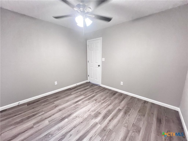 spare room with a ceiling fan, baseboards, and wood finished floors