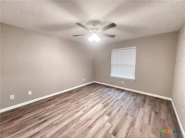 unfurnished room featuring ceiling fan, a textured ceiling, baseboards, and wood finished floors