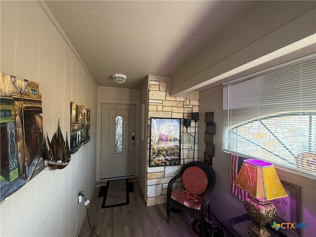 entryway with wooden walls, hardwood / wood-style floors, and ornamental molding