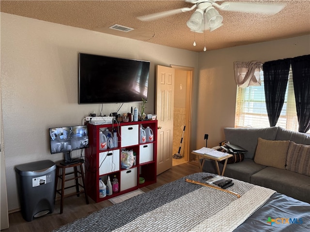 bedroom featuring ceiling fan, wood-type flooring, and a textured ceiling