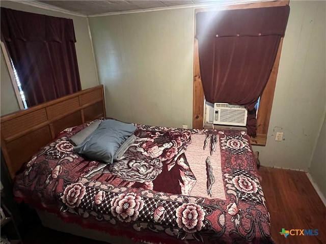 bedroom with ornamental molding, cooling unit, and wood-type flooring