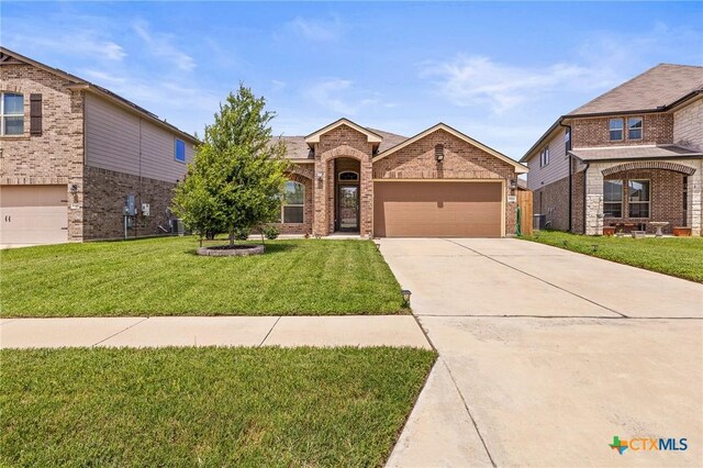 853 Hobby Rd, Copperas Cove, TX 76522 - traditional-style house featuring brick siding, a garage, driveway, a front lawn, and central air condition unit
