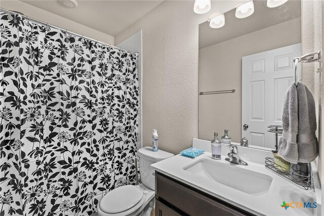 853 Hobby Rd, Copperas Cove, TX 76522 - full bathroom with a textured wall, vanity, toilet, and a shower with curtain