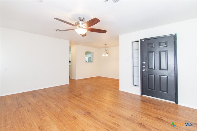 entryway with ceiling fan with notable chandelier and light hardwood / wood-style flooring