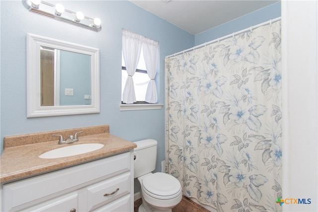 bathroom featuring toilet, vanity, and walk in shower