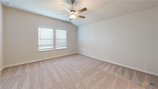 unfurnished room with light colored carpet, ceiling fan, baseboards, and vaulted ceiling