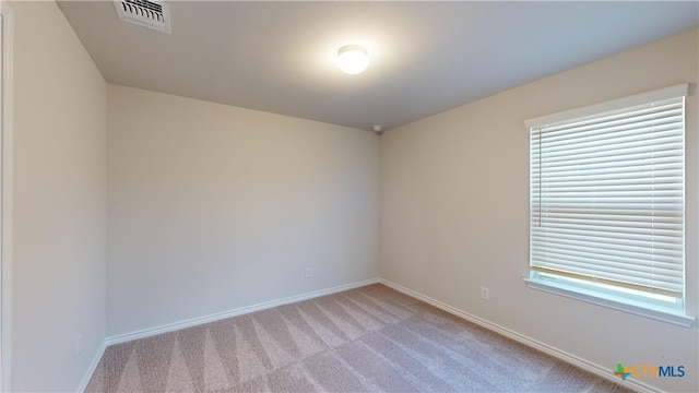 unfurnished room featuring visible vents, baseboards, and light carpet