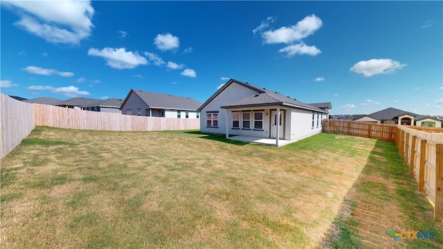 back of property with a fenced backyard, a patio area, and a yard