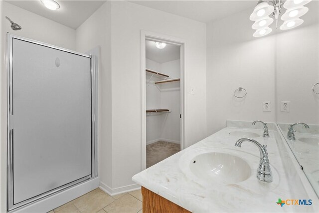 3511 Llano Estacado Ct, Killeen, TX 76549 - bathroom featuring a stall shower, a walk in closet, double vanity, and tile patterned flooring
