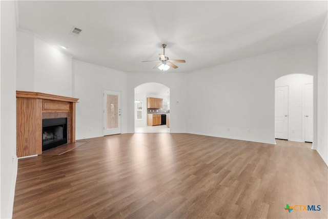 3511 Llano Estacado Ct, Killeen, TX 76549 - unfurnished living room with arched walkways, ceiling fan, a fireplace, and wood finished floors
