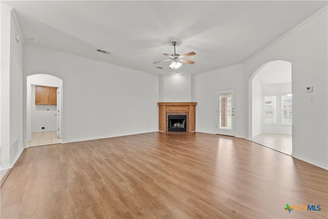3511 Llano Estacado Ct, Killeen, TX 76549 - unfurnished living room featuring arched walkways, ceiling fan, ornamental molding, light wood-style flooring, and a fireplace