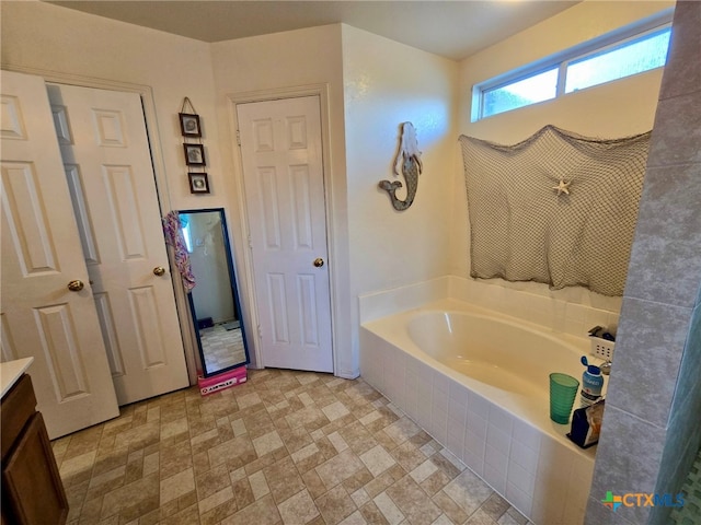 bathroom with vanity and tiled tub