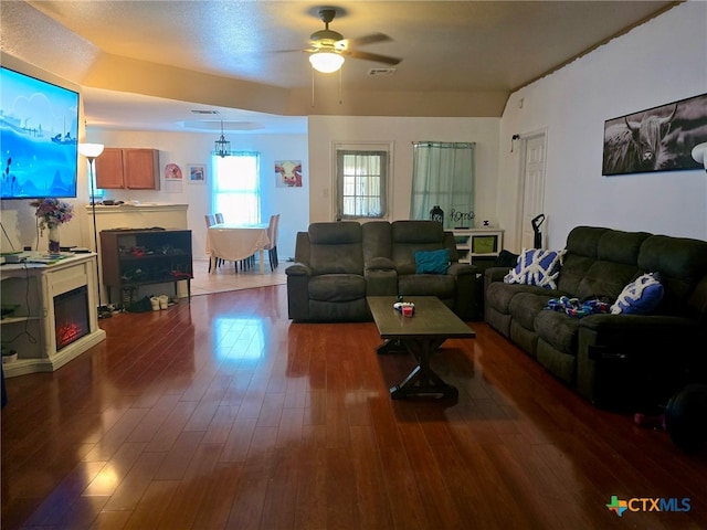 living room featuring ceiling fan and dark hardwood / wood-style floors