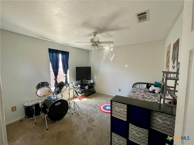 playroom featuring carpet, a textured ceiling, and ceiling fan