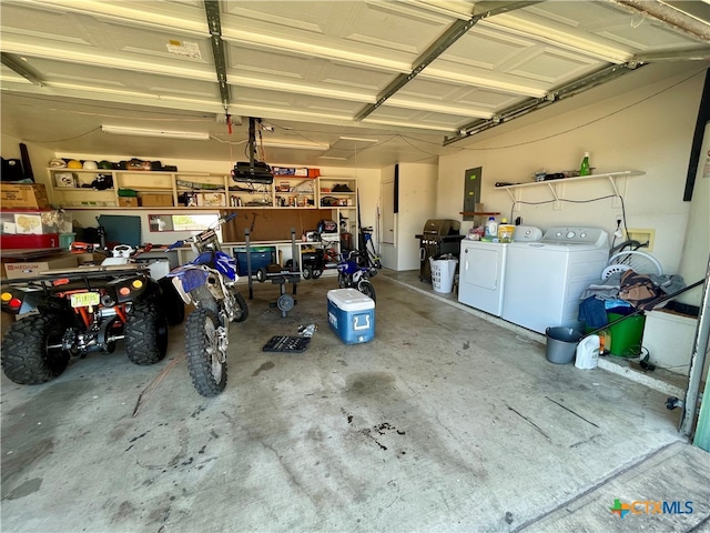 garage with electric panel and washer and dryer