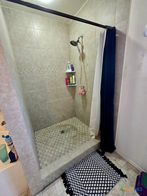 bathroom with a shower with curtain and tile patterned floors