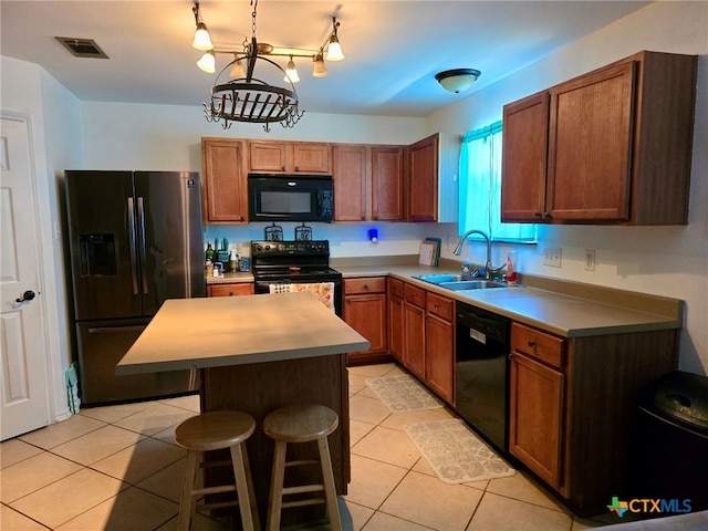 kitchen with sink, black appliances, light tile patterned floors, a chandelier, and a kitchen island