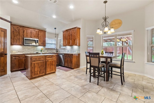 2034 Falling Leaf Ln, Harker Heights, TX 76548 - kitchen with a notable chandelier, appliances with stainless steel finishes, a sink, decorative backsplash, and vaulted ceiling