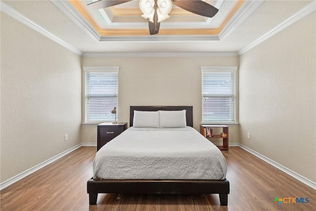 2034 Falling Leaf Ln, Harker Heights, TX 76548 - bedroom featuring light wood-style floors, a raised ceiling, ornamental molding, and baseboards