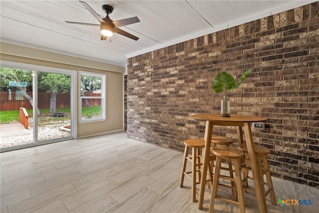 2034 Falling Leaf Ln, Harker Heights, TX 76548 - unfurnished dining area with a ceiling fan, brick wall, and light wood finished floors